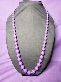 This is a very pretty vintage purple beaded necklace. The beads are in graduating sizes with the bigger ones in the front. They have light gold tone spacer disc beads between every purple bead. The spring ring closure is gold tone. It measures approximately 30 inches in total length. It is pre-owned and may have minor wear, but still looks to be in great condition. Elegant Purple Beaded Necklace With Round Beads, Lavender Beaded Necklaces With Round Beads, Purple Single Strand Beads As A Gift, Purple Beaded Necklace With Faceted Beads, Lavender Beads For Jewelry Making, Purple Round Beaded Necklace With Faceted Beads, Adjustable Purple Beaded Necklaces With Large Beads, Purple Beaded Necklaces With Large Round Beads, Adjustable Purple Beaded Necklace With Large Beads