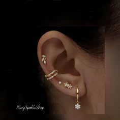 the ear is adorned with three different types of piercings