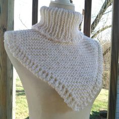 a mannequin with a white knitted shawl on it's back