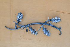 a branch with leaves on it sitting on top of a wooden table