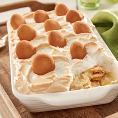 a casserole dish filled with food on top of a wooden cutting board