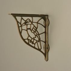 a decorative metal shelf with a bird on it's back and an ornate design