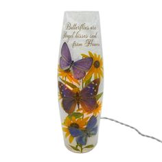 a glass vase with butterflies and flowers painted on the side, sitting against a white background