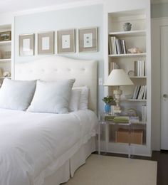 a bed with white sheets and pillows in a bedroom