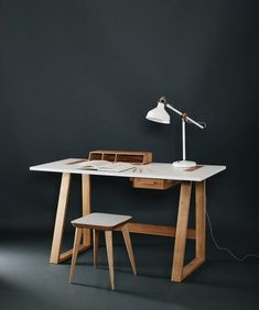 a desk with a lamp on it next to a chair