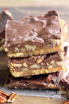 three pieces of chocolate pecan bar stacked on top of each other with pecans