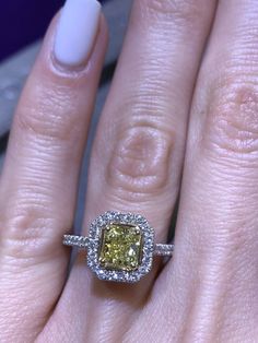 a woman's hand with a yellow and white diamond ring