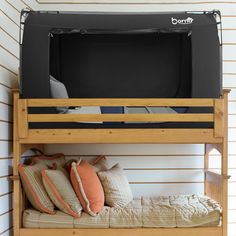 there is a bunk bed with a tv above it and pillows on the bottom shelf