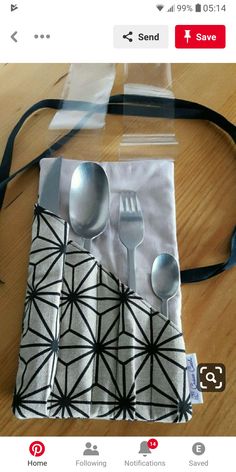 silverware and spoons are sitting on a napkin with a black ribbon around it