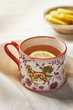 a cup of tea with lemon slices on the side