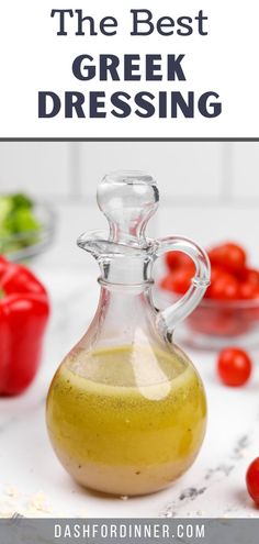 the best greek dressing recipe in a glass bottle with tomatoes and peppers on the side