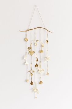 a gold leaf and vine mobile hanging on a wall