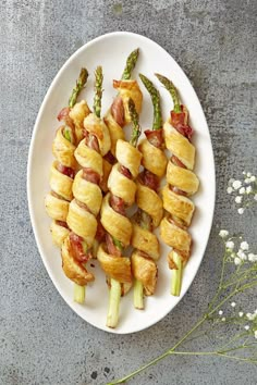 asparagus wrapped in bacon on a white plate