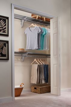 an open closet with clothes and baskets on the floor