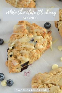 blueberry scones with white chocolate drizzled on top and fresh blueberries scattered around