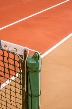 a tennis court with a net on the side and a ball in the back ground