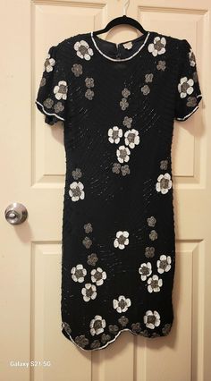 This dress is from the 1980s but it looks like a dress from 1939 Black Silk dress, hand embellished with a crystal bead floral design, white sequin and Pewter embroideries The bead work was all hand done.  Sheath style with padded shoulders and short sleeves Keyhole back with a zipper and hooks Very good excellent condition, an inch or two of white sequins missing at the back keyhole No designer label 100% Pure Silk Rayon lining Petite size 8 Medium Petite Bust 38" Waist 28" Hips 40" Length 42" Black Silk Dress, Sequined Dress, Designer Label, Super Cute Dresses, Petite Size, Black Silk, Dress Clothes For Women, Sequin Dress, Pure Silk