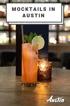 a drink sitting on top of a wooden table next to a sign that says cocktails in austin