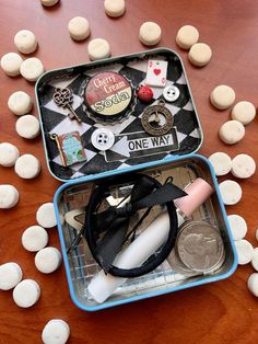 two tins filled with different items sitting on top of a table