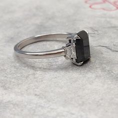 a black diamond ring sitting on top of a table