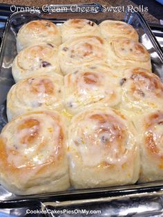 a pan filled with cinnamon rolls sitting on top of a stove