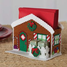 a small house made out of beads with candy canes on the front and side