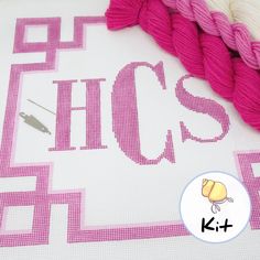 the cross stitch pattern is being worked on with yarn and scissors to make it look like they are knitting