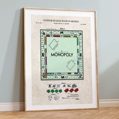 a monopoly board game on the floor in front of a wall with an advertisement for it