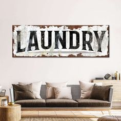 a living room filled with furniture and a large sign on the wall above it that says laundry