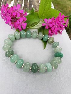 This gorgeous green aventurine bracelet is sure to call a lot of attention! It has large genuine green aventurine gemstones and silver spacer beads. Aventurine is a magical stone that brings you luck, prosperity, abundance, and it opens the path for new opportunities.  Go out into the world in style and with all the positive energy that this wonderful stone is sure to bring! Proper Sizing: Wrap a string around your wrist or around the area where you would like the bracelet to sit.  Measure that Green Amazonite Bracelet With Natural Stones, Green Bracelets With Natural Stones, Green Stretch Bracelet With Natural Stones For Healing, Green Amazonite Beaded Bracelets With Natural Stones, Green Aventurine Gemstone Beaded Bracelets, Green Amazonite Round Bead Bracelets, Healing Green Stretch Bracelet With Natural Stones, Green Aventurine Stretch Bracelet With Natural Stones, Green Aventurine Stretch Bracelet Gift