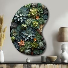 a wall mounted art piece with succulents and plants on it's side