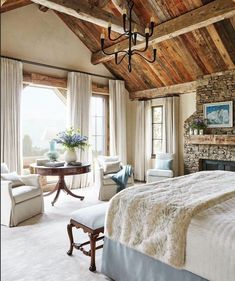 a bedroom with a fireplace, chairs and a bed