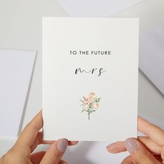 two hands holding up a card that says, to the future mrss with flowers on it