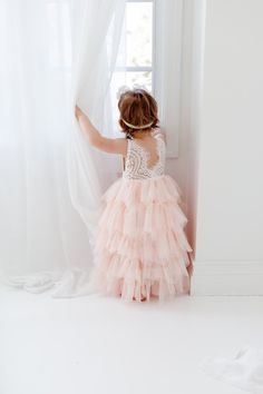 This dress is just beautiful! It includes a delicate white lace bodice with tiered blush pink tutu skirt. It also has an embellished sash on the front that is not removable. The V Back with unfinished lace adds the perfect amount of boho chic look to this amazing Tea length dress. Perfect for your next special event. Nicolette's Couture is a family owned boutique based out of Dubuque, Iowa. When creating looks, comfort is our main priority...regardless of how chic a style is. We've had amazing s Blush Flower Girl Dresses, Pink Tutu Skirt, Dress Blush Pink, Dubuque Iowa, Lace Flower Girl Dress, Pink Flower Girl Dresses, White Lace Wedding Dress, Tulle Wedding Gown, Heirloom Dresses