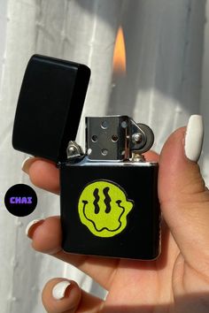 a person holding a lighter with a smiley face on it