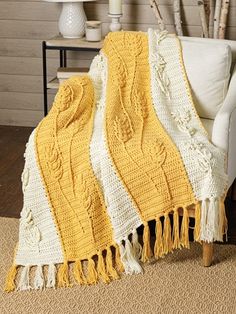 a yellow and white blanket sitting on top of a couch