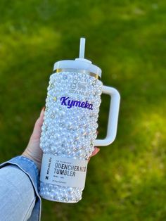 a person holding a coffee cup in their left hand with the words kynka on it