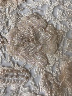 the fabric is made up of silver and gold sequins with flowers on it