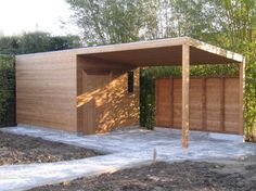 a wooden structure in the middle of a garden with trees and bushes around it,