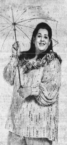 an old black and white photo of a woman holding an umbrella