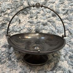 an old fashioned metal bowl on a rug