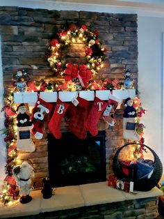 a fireplace decorated for christmas with stockings and lights