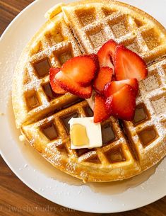 a waffle topped with strawberries and butter on a white plate