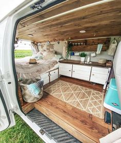 the interior of a camper van with wood flooring and storage area in the back