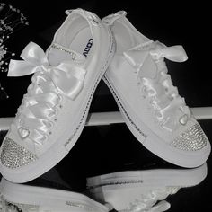 Dance the night away in comfort and style in these stunning all white dazzling Converse.  Custom hand embellished with the finest glass crystals for that extra sparkle to toes, around logo, backs with crystal edged bows, between eyelets and along inner and outer soles. Each crystal is individually placed and secured with industrial glue to achieve the perfect finish. The shoes are finished with grade A diamante  ribbon sliders on white satin ribbon laces. Ribbon colour can be changed to match a colour scheme. Please just ask. All shoes are authentic and made to order. **SIZING INFORMATION** Please note that orders are taken using UK sizing. A conversion chart is included in the listing to assist you. Please make sure you order your size correctly due to the bespoke nature of the shoes. If Converse Bride, Bride Converse, Bridal Converse, Bling Converse, Converse Custom, Wedding Converse, Ribbon Laces, Wedding Socks, Wedding Sneakers