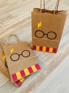 two harry potter bags with glasses on them sitting on a wooden floor next to each other