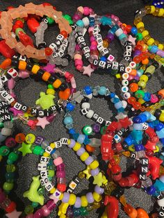 a pile of beads and bracelets sitting on top of a table next to each other