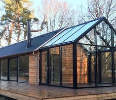 a small wooden house with glass doors and windows