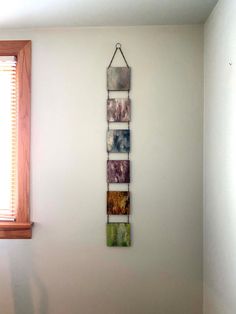 a white wall with four pictures hanging on it's side next to a window