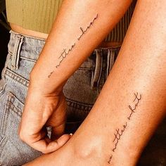 two people with matching tattoos on their legs, one is holding the other's hand